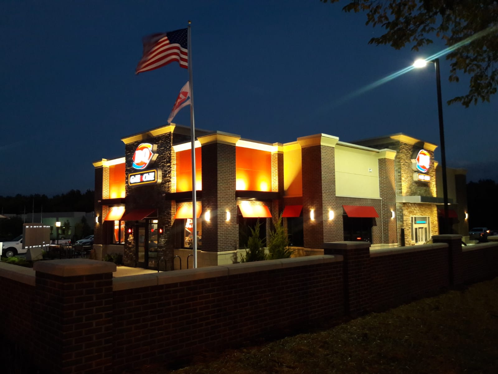 Dairy Queen Franchise building at night with a waving flag